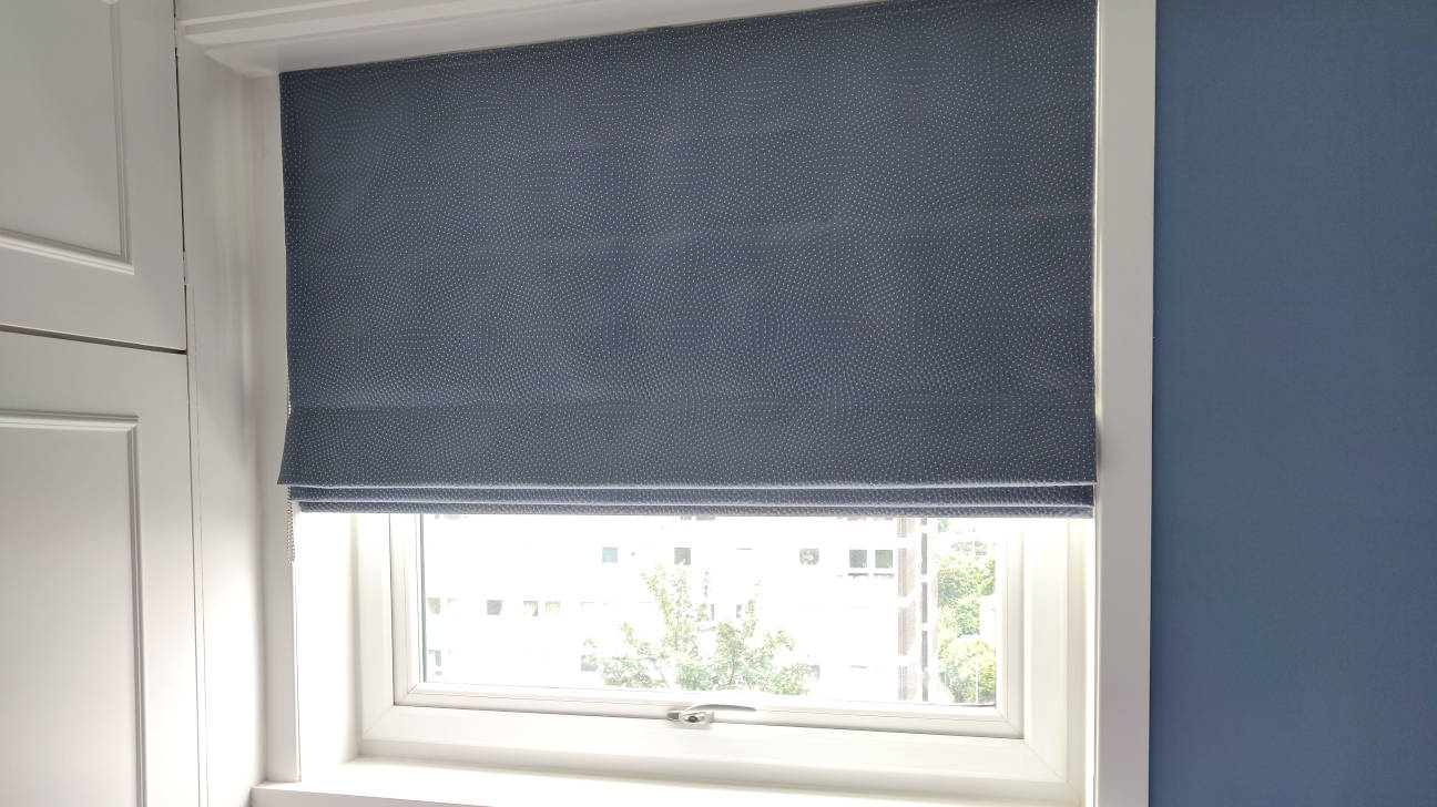 Bedroom with luxurious custom Roman blinds